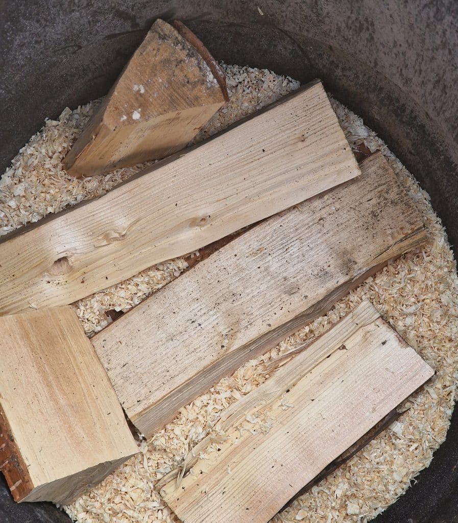 The Oil Drum Kiln - It's Easy to Sawdust Fire Pottery 9 adding wood to the oil drum kiln